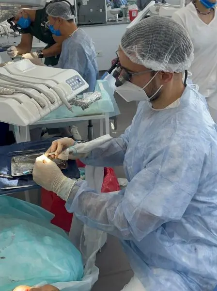 A clinician preparing the instrument tray beside the chair during the course