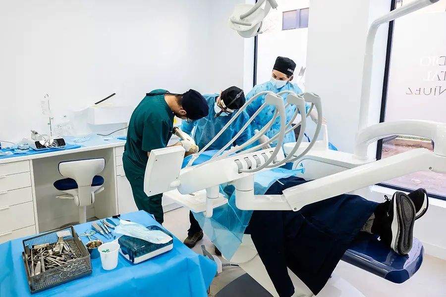Two clinicians at the chair, with the instrument tray in the foreground